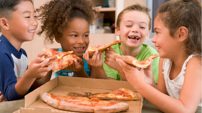 vier kinderen eten samen een pizza